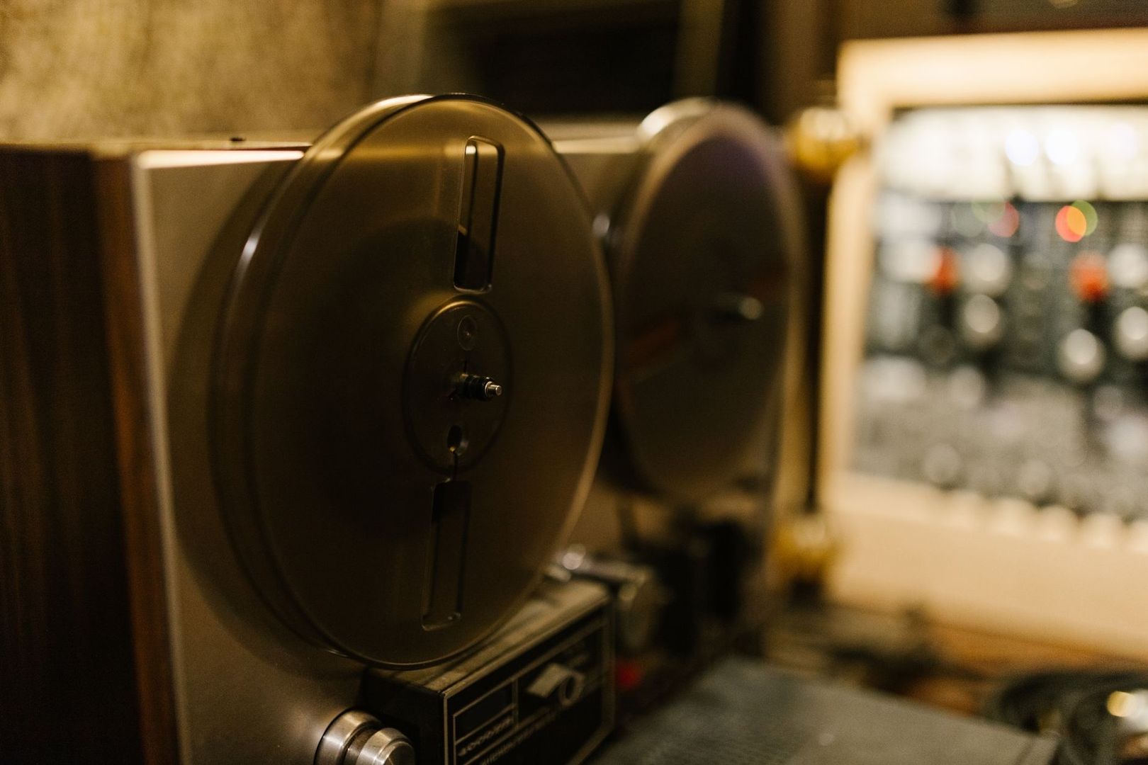 Nahaufnahme einer vintage Tonbandmaschine im warm beleuchteten Studio